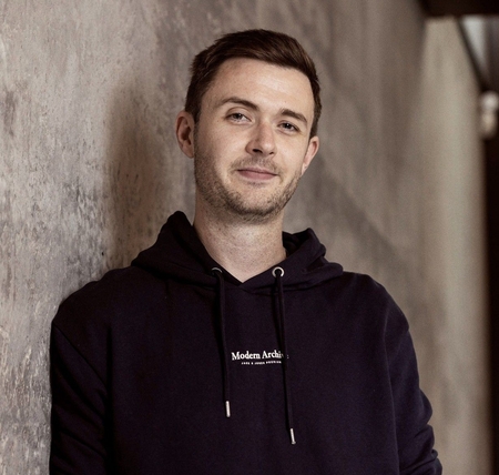 Carl Reid smiling, wearing a navy hoodie